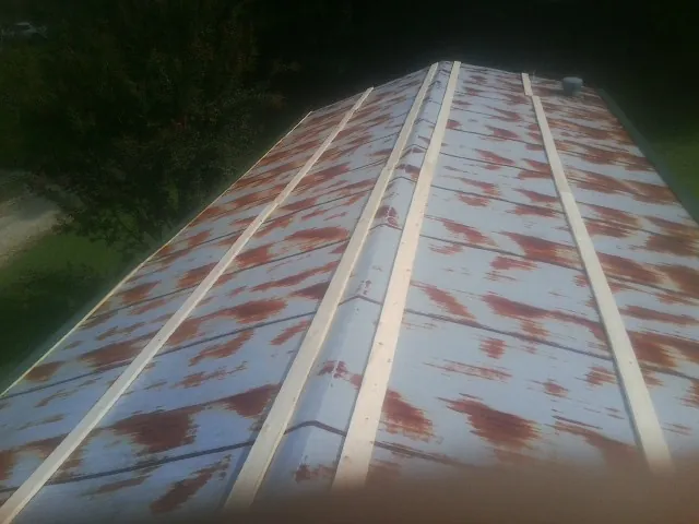 Rusted metal roof panels with new wood purlins before replacement — Storm Damage Roof Repair in Effort by Roofing Brothers