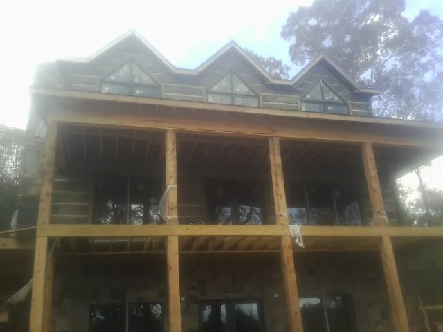 Dormers and porch framing on a large log home under construction — Roof Coating work by our crew in Effort
