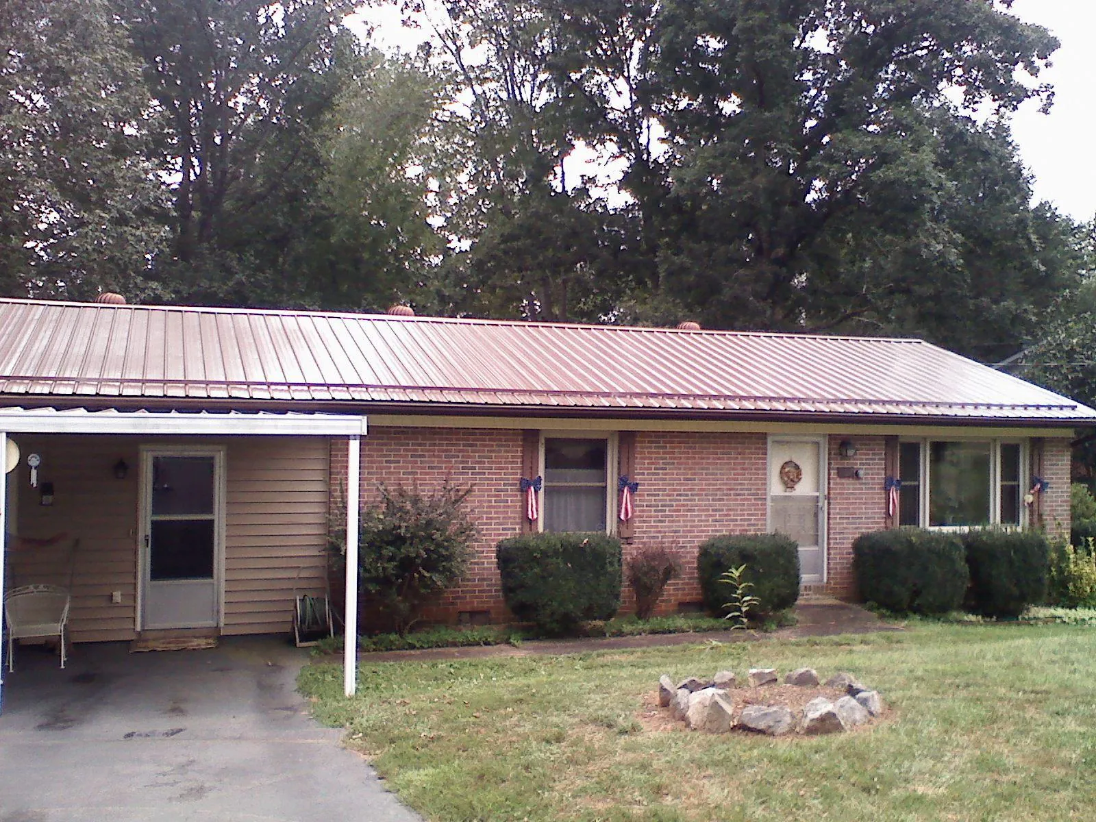 Bronze metal roof and carport on a brick ranch home — Roof Repair work by our crew in Effort